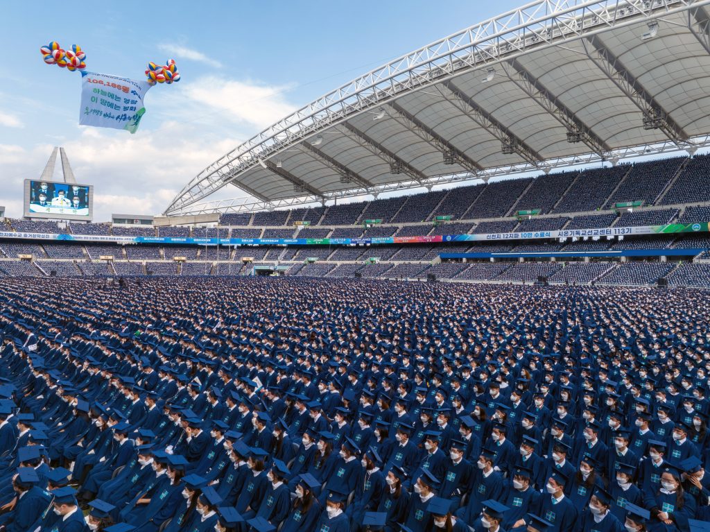 Gefülltes Stadion in Daegu, voller Absolventen in Abschlussroben.