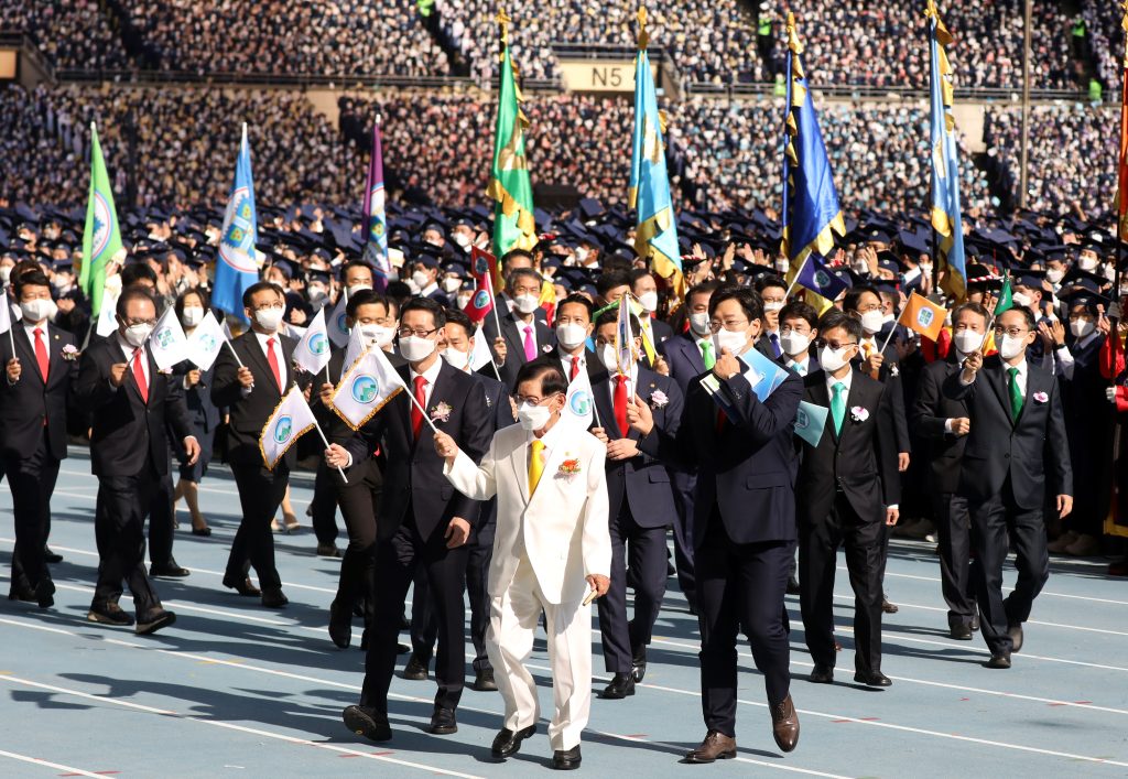 Lee Man-Hee und die Stammesleiter laufen in das Stadion ein.
