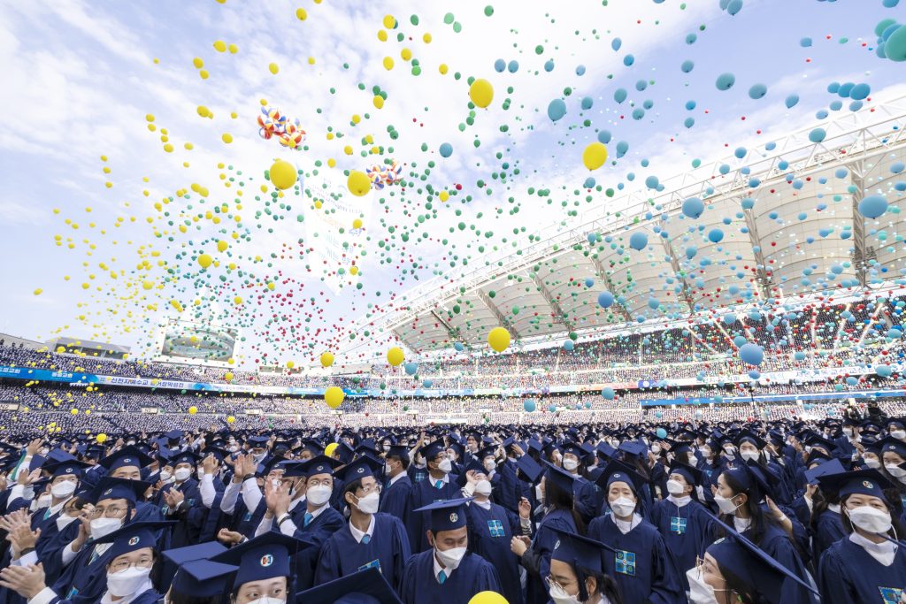 Absolventen lassen farbige Ballons steigen.